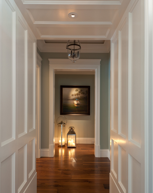 Hallway with white paneling and detailed custom millwork, showcasing architectural drafting, precision trim work, and refined transitional-style craftsmanship.
