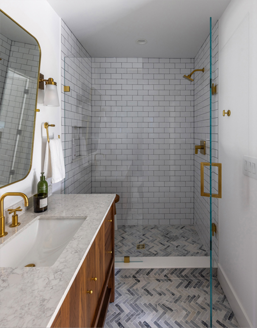 Elegant guest bath with marble tile, modern lighting, and clean lines — upscale bathroom design by a Colorado interior design firm