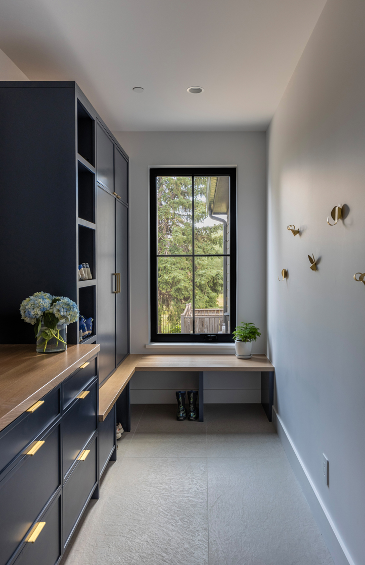 Custom blue mudroom with vertical paneling and integrated storage — functional and stylish entry design by Denver interior designers