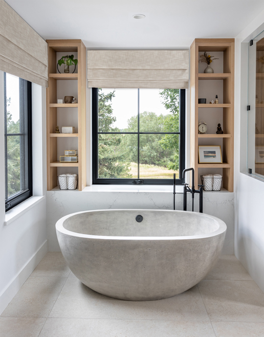 Organic-shaped freestanding tub in a calm, earthy primary bath — Colorado interior design with natural material inspiration