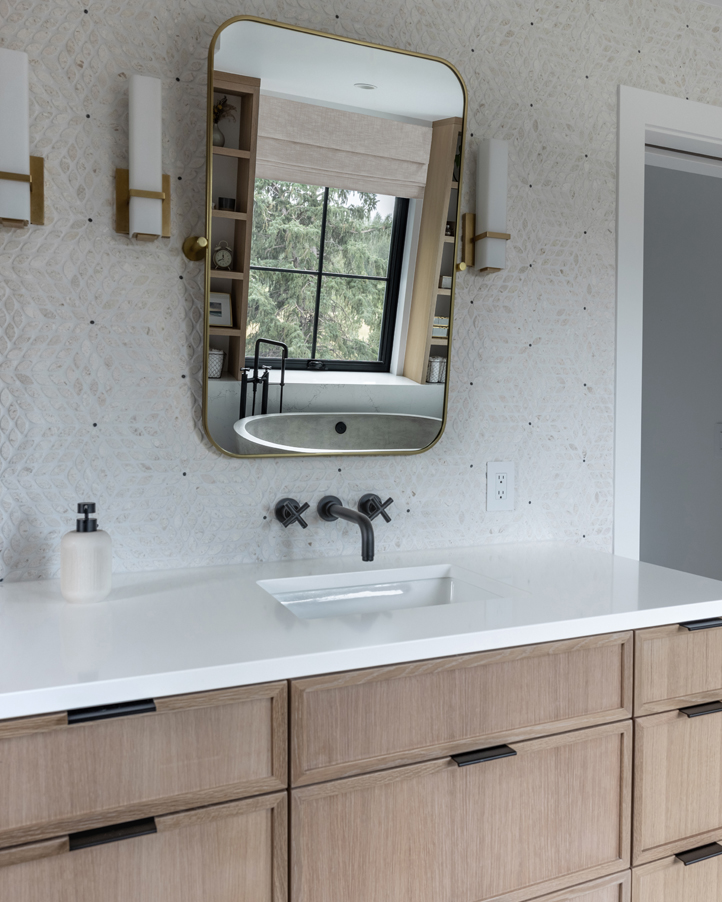 Elegant bathroom mirror with brass sconces and quartz counters in a Boulder primary suite — timeless style from a Colorado design studio